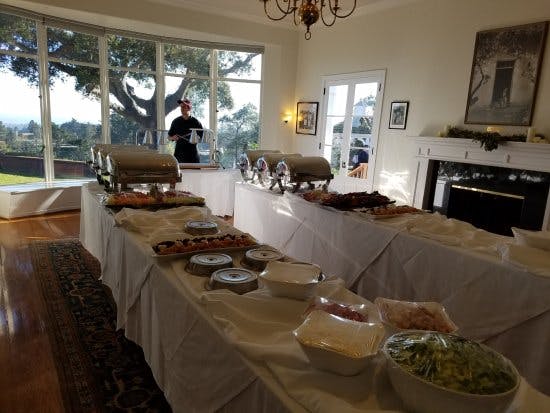 Elegant buffet setup at The Hollins House for events, featuring chafing dishes and natural light.