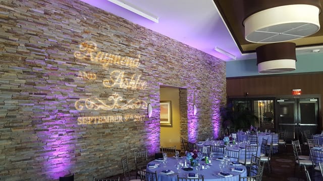 Elegant wedding venue with lavender tables and personalized gobo projection.