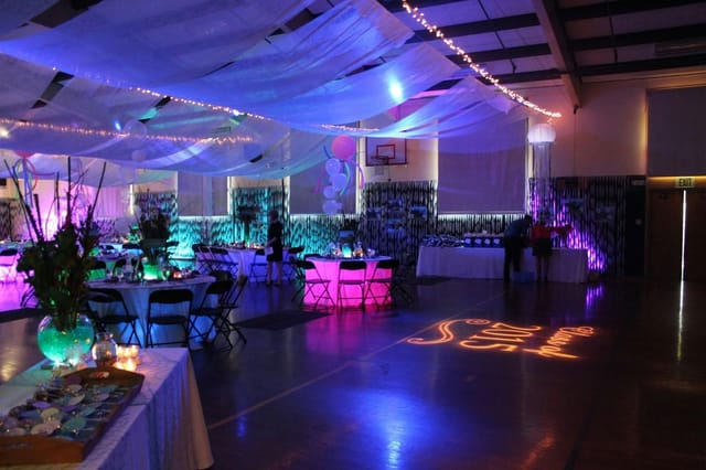 Elegant event space with colorful uplighting for formal gatherings and celebrations.