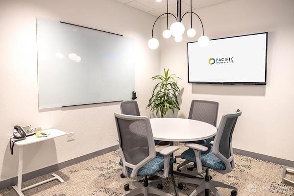 Modern meeting room with round table, ideal for team collaboration and brainstorming.