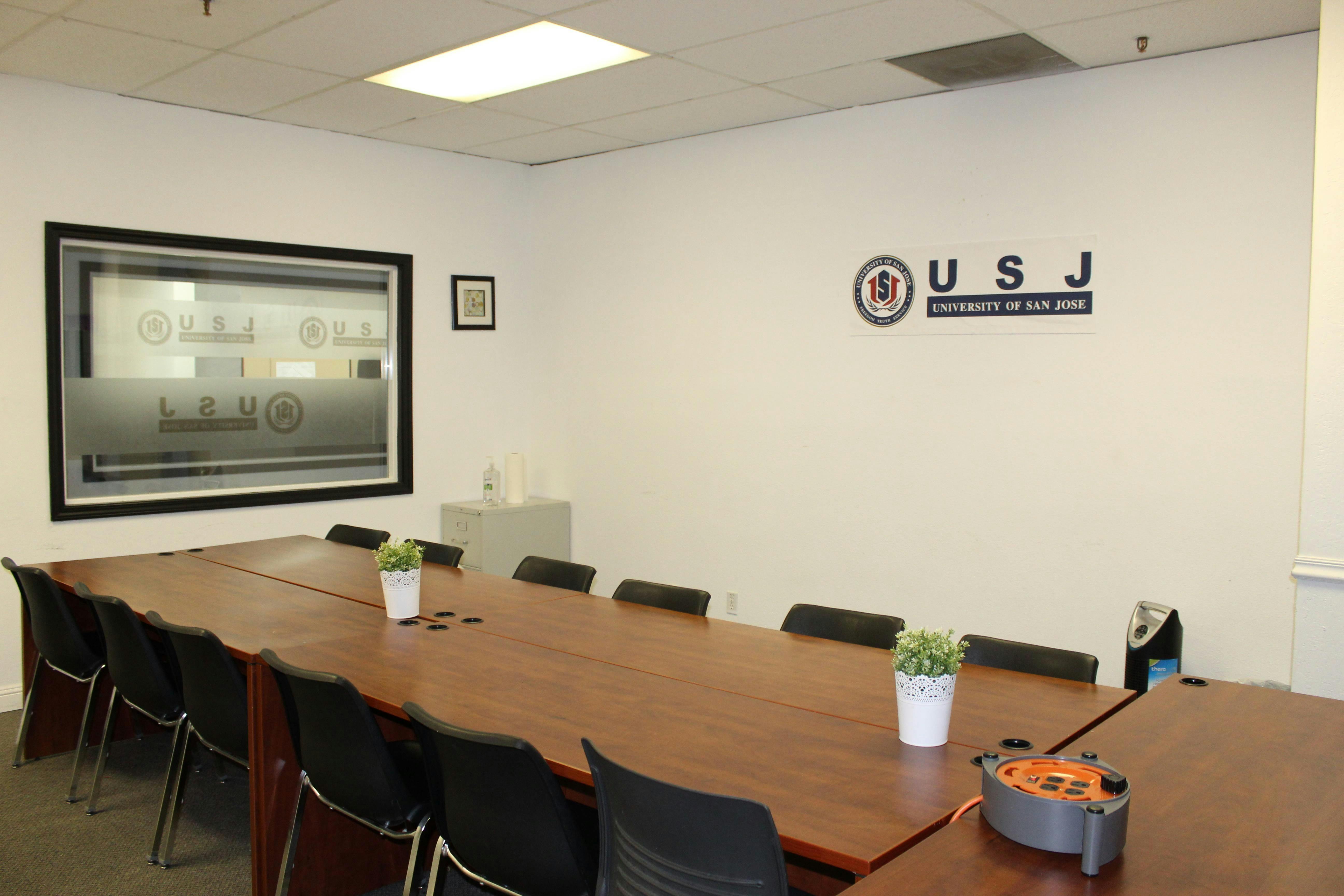 Conference room at San José State University with a long wooden table for meetings.