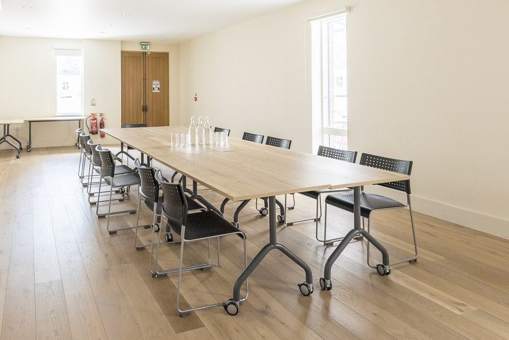 Modern meeting room with long table, ideal for collaborative discussions and events.