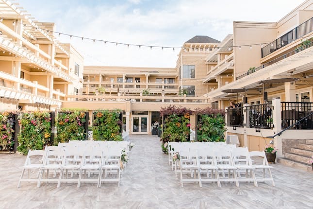 Outdoor wedding venue at Toll House Hotel with white chairs and elegant string lights.