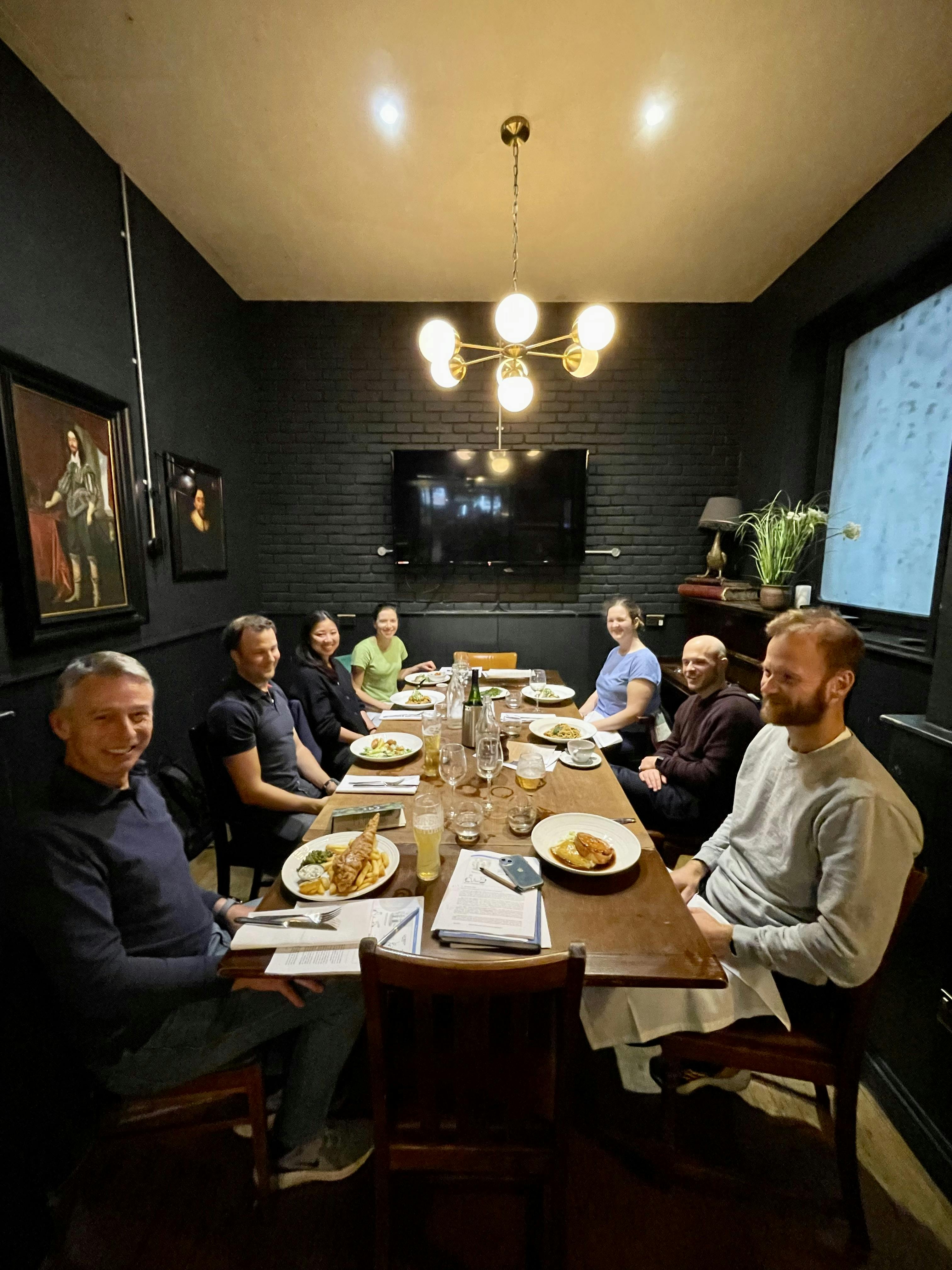 Cozy dinner meeting in The Tokenhouse with warm lighting and round table for networking.