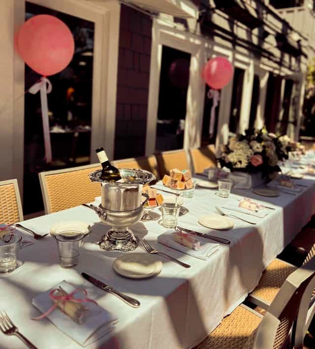Elegant outdoor dining setup in Piatti Sacramento with floral arrangements and wine.