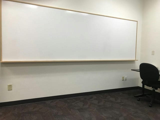 Minimalist meeting room with whiteboard for focused discussions and workshops.