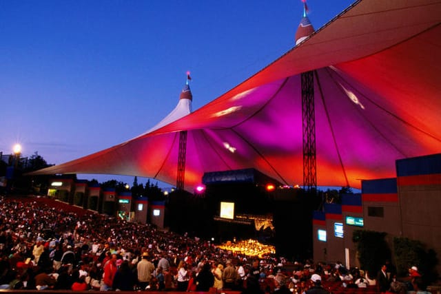 Shoreline Amphitheatre concert venue with colorful canopy and large audience.