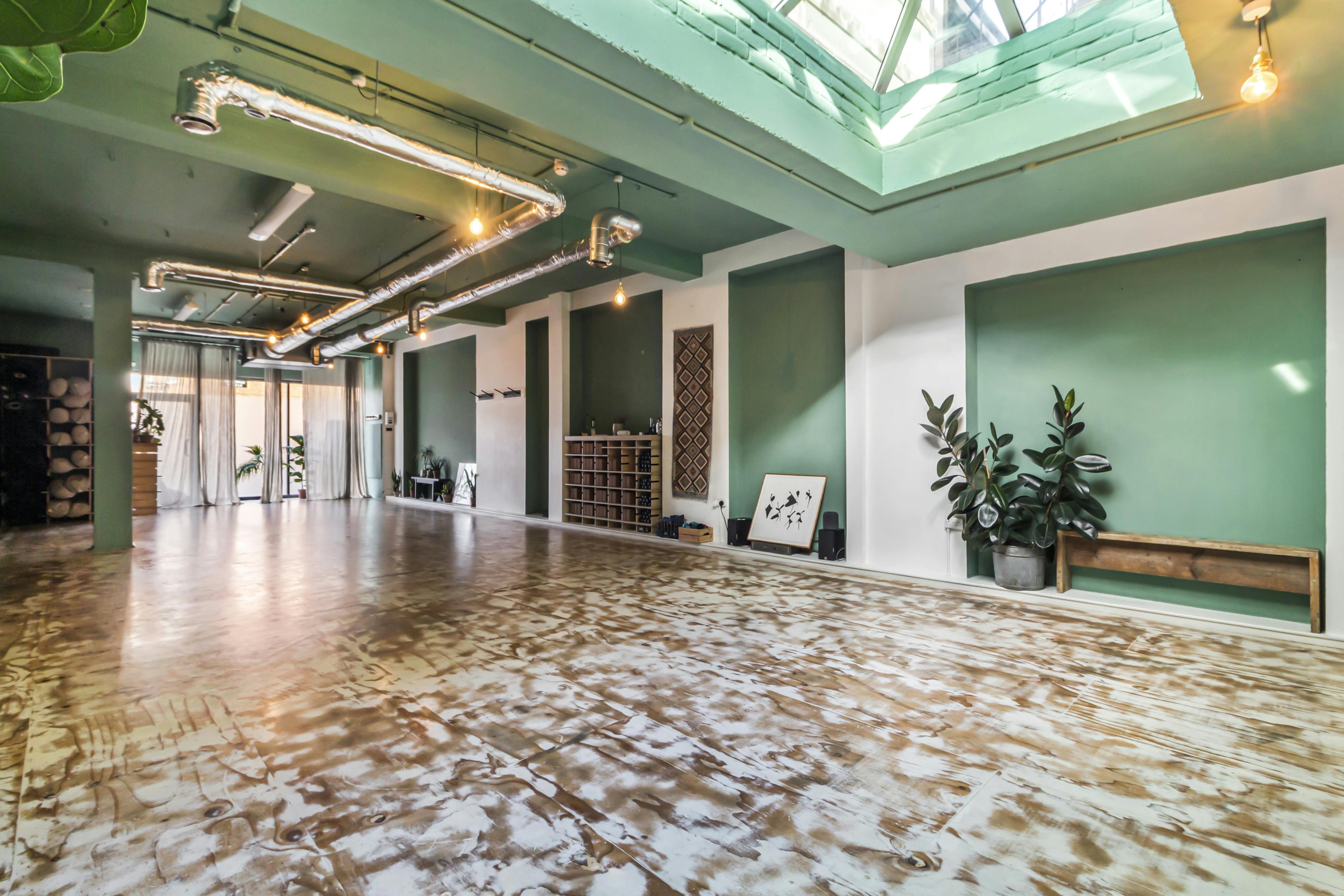 Modern yoga studio with skylights, perfect for workshops and social gatherings.