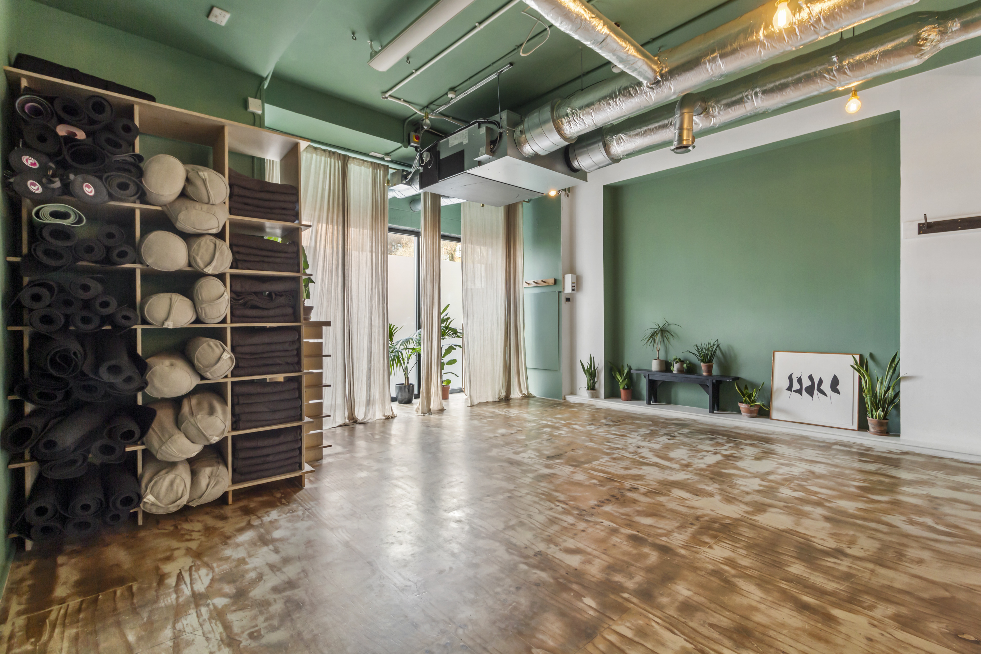Yoga studio with green decor, ideal for fitness classes and wellness workshops. - Banner