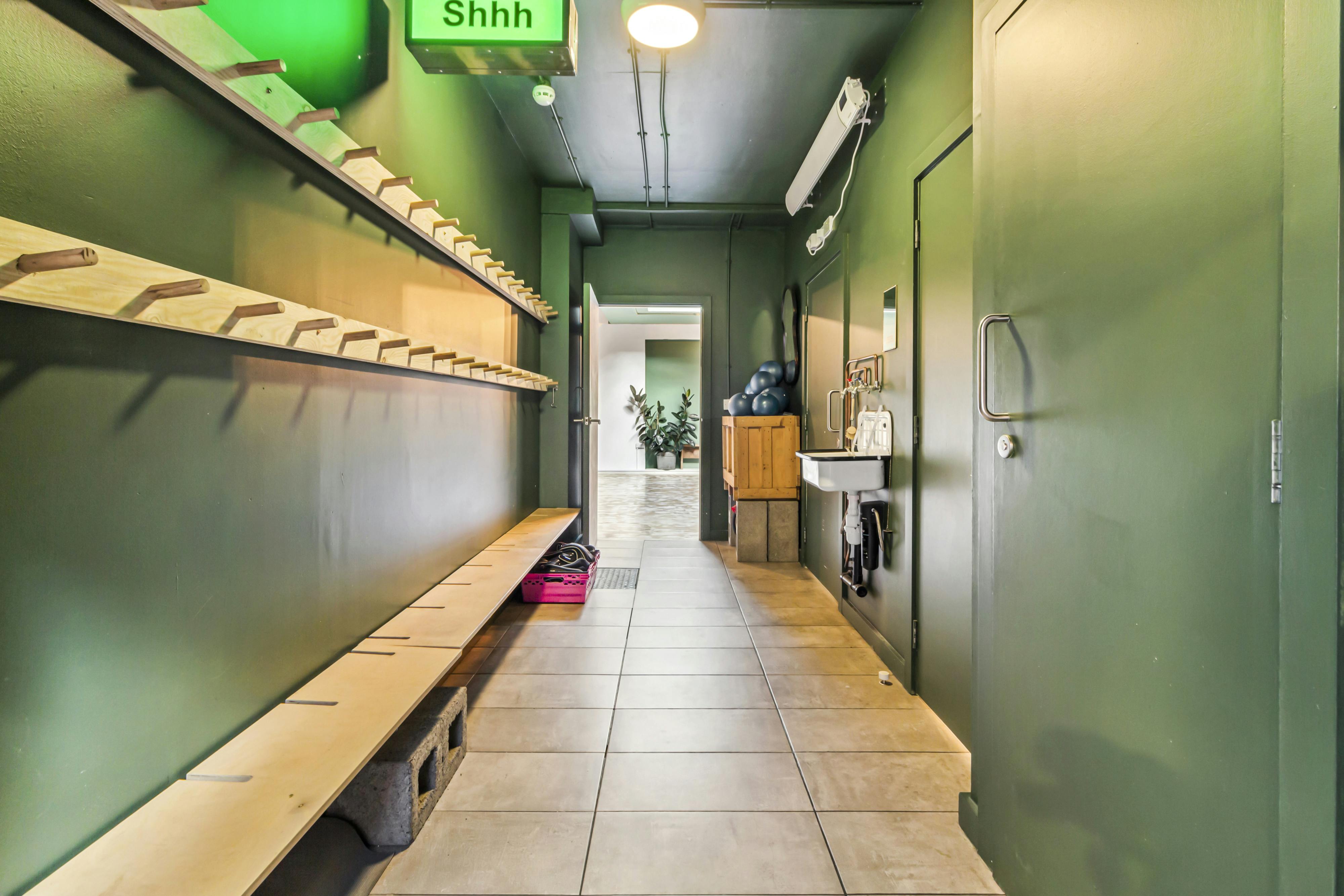 Yoga studio hallway with green walls, ideal for events and check-ins.