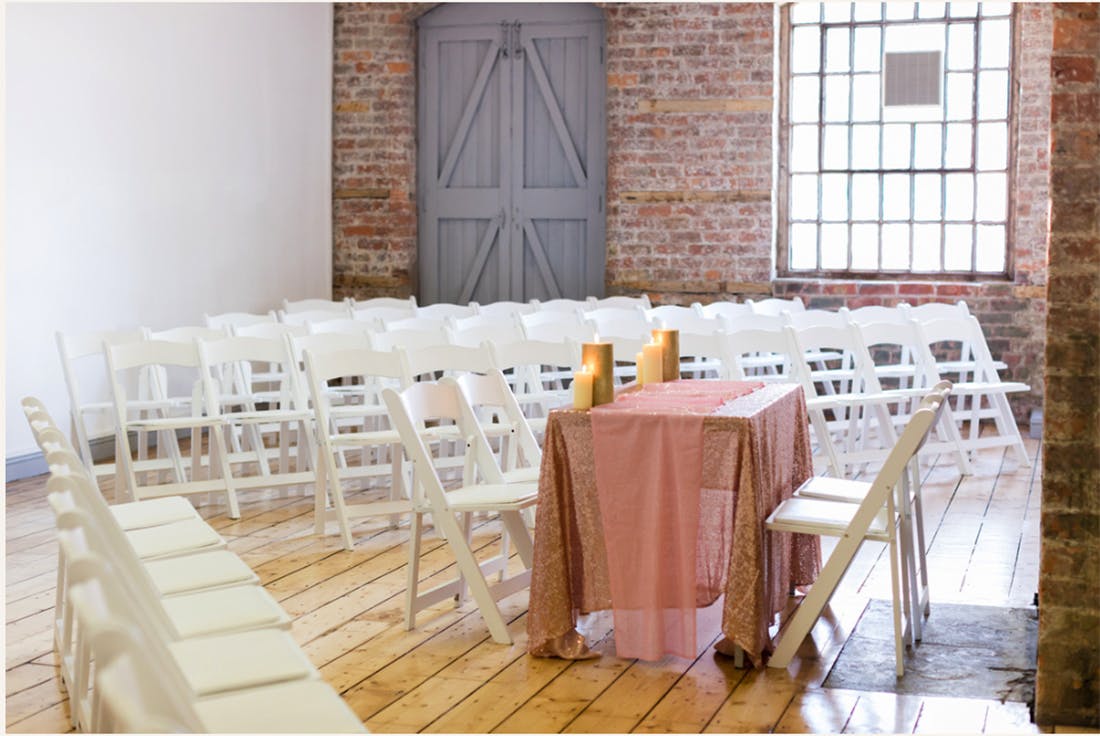 Intimate event space with white chairs, ideal for workshops and small meetings.