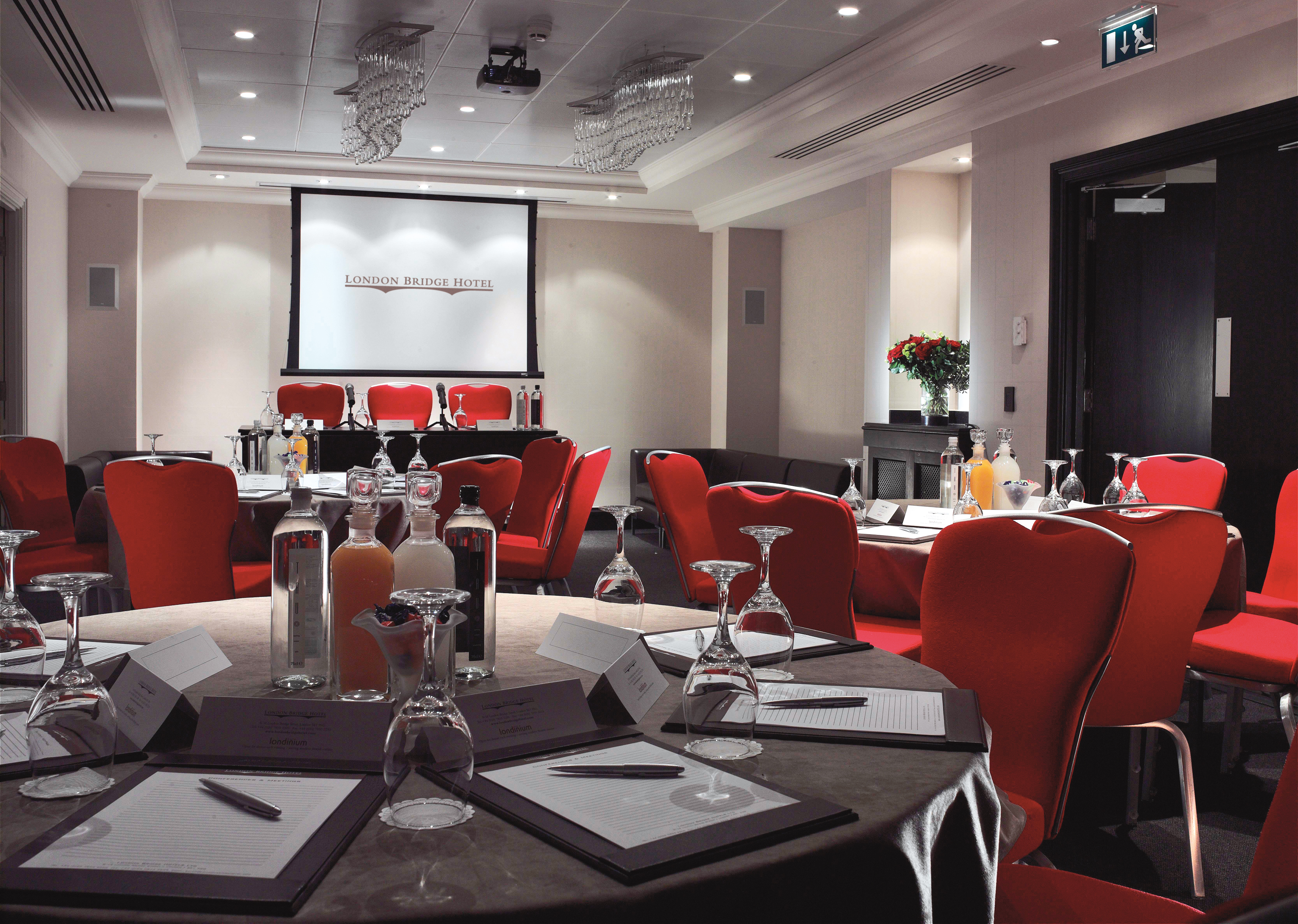 Shakespeare Suite meeting room with round tables, red chairs for corporate events. - Banner