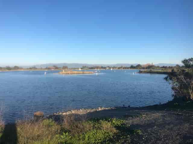 Serene Shoreline Lake venue with calm water, ideal for outdoor events and retreats.