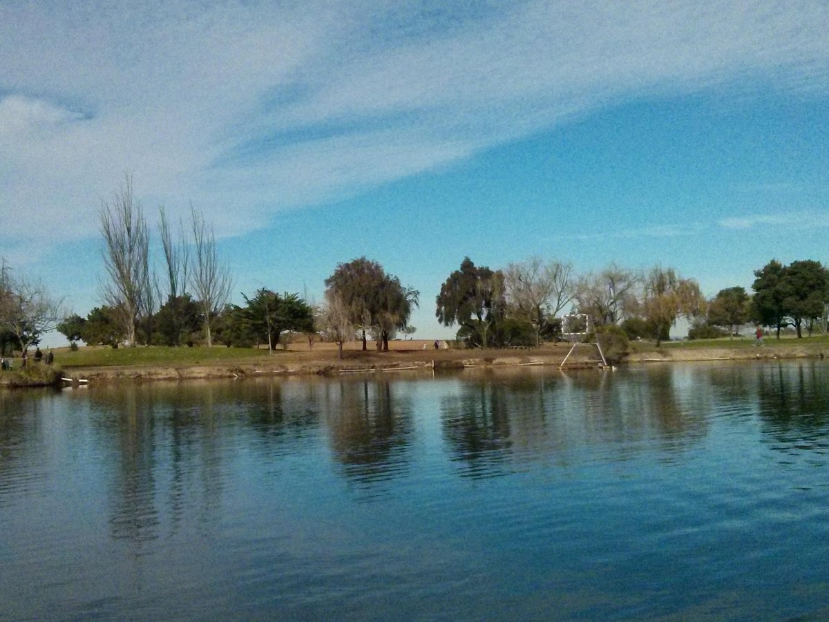 Serene lakeside venue with lush greenery for outdoor events and gatherings.
