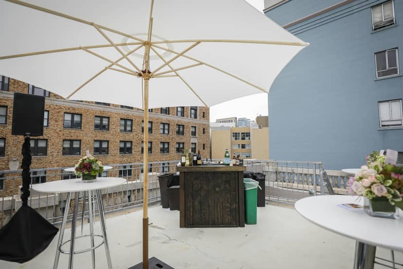 Stylish rooftop event space with bar and floral decor, ideal for gatherings and receptions.