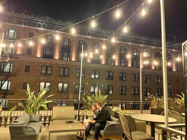 Cozy rooftop event space with string lights, perfect for networking and receptions.