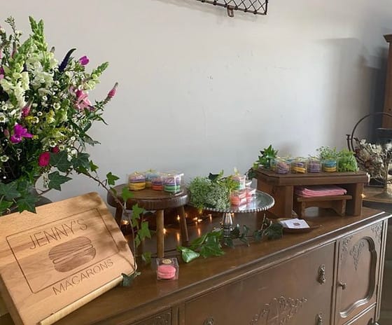 Vintage dessert table with colorful macarons and floral display for events.