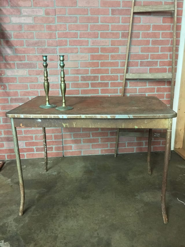 Vintage rustic table with brass candlesticks for intimate events and gatherings.