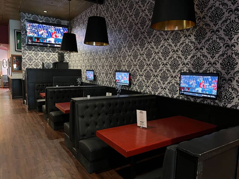 Stylish patio with booth seating at The Brit Sports Pub, ideal for events and gatherings.