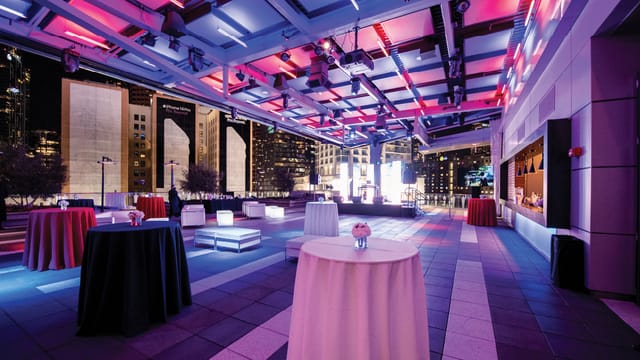 Stylish rooftop event space with vibrant lighting for upscale gatherings and corporate events.
