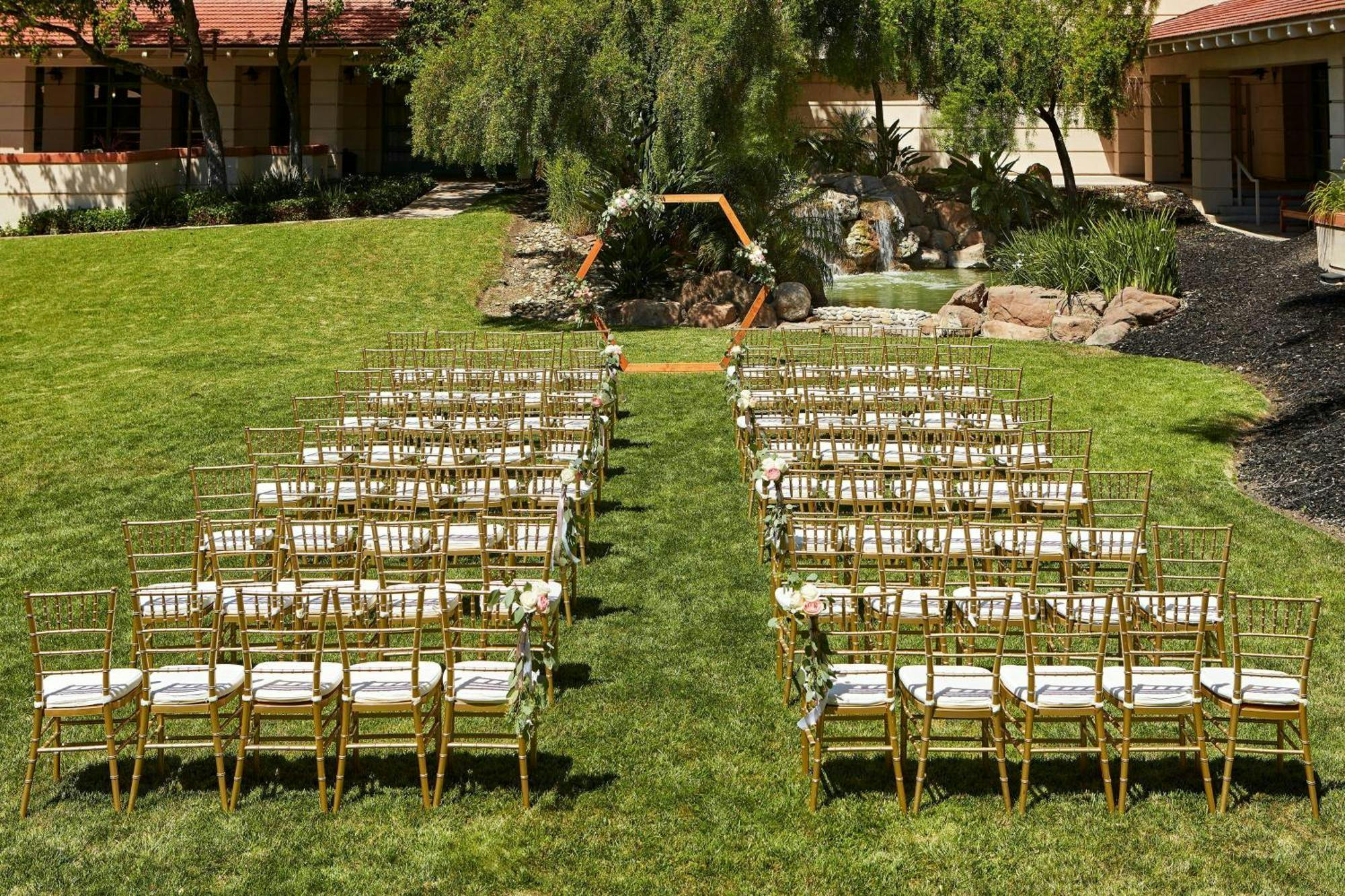 Outdoor wedding ceremony at The Bistro, Sheraton San Jose, with gold chiavari chairs.