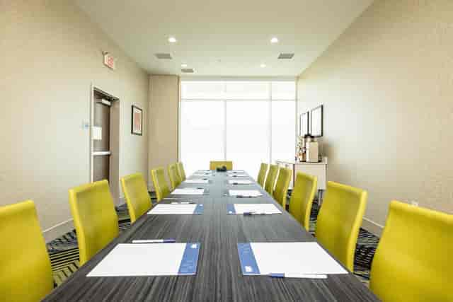 Modern meeting room with yellow chairs at Holiday Inn Express, perfect for workshops.