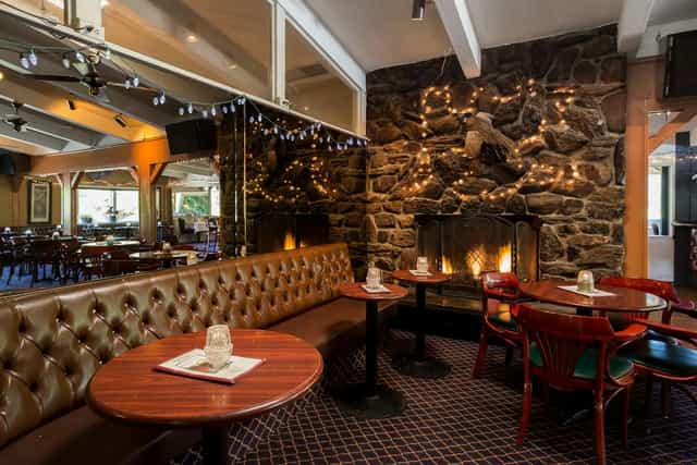 Cozy banquet area with plush seating and fireplace for intimate gatherings or events.