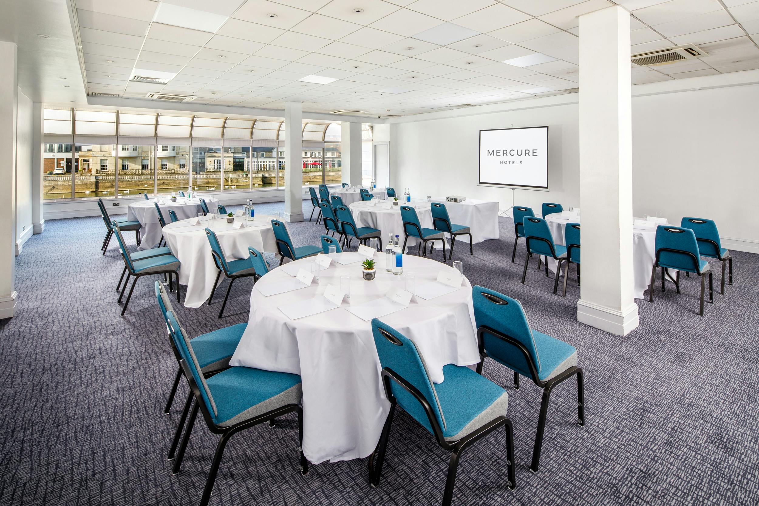 Pilgrim Suite meeting room with round tables, ideal for corporate events and workshops.