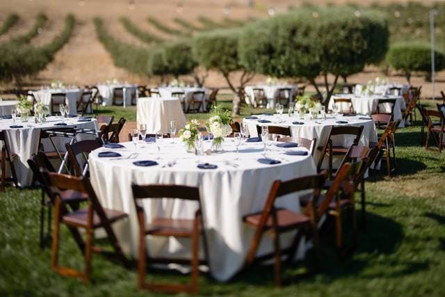 Elegant outdoor banquet hall setup with cream tables, perfect for weddings and corporate events.