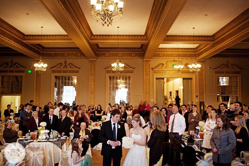 Elegant wedding reception in Historic Ballroom, featuring floral centerpieces and warm lighting.