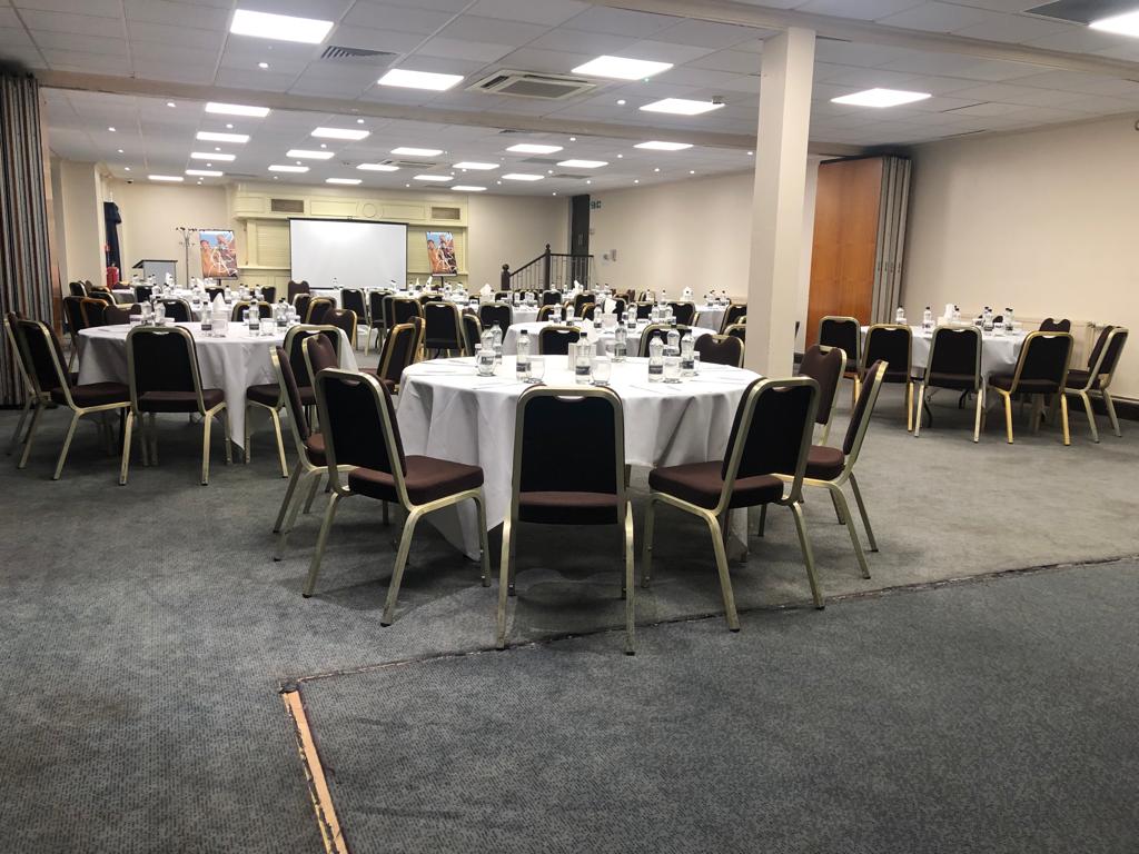 St David's Suite at Mercure Cardiff North Hotel, spacious event space with round tables. - Banner