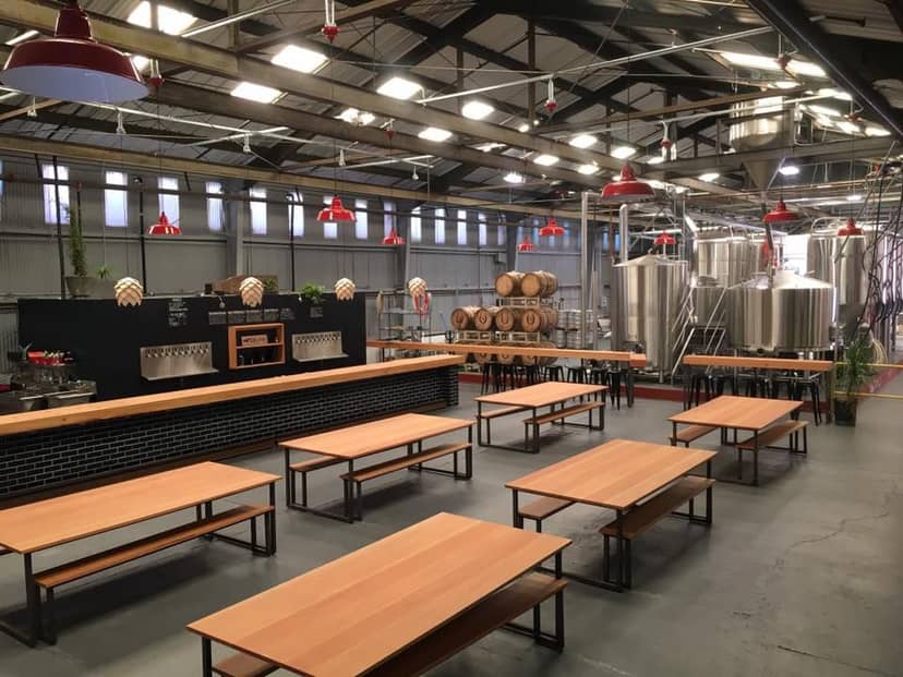 Spacious industrial lounge at Barebottle Brewing Co. for events and gatherings.