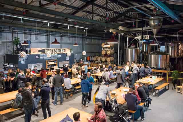 Vibrant brewery lounge with communal tables for social events and networking.