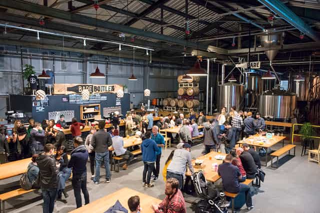 Vibrant brewery lounge with communal tables for social events and networking.