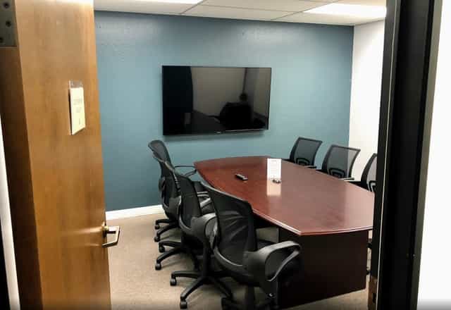 Lounge room with wooden conference table, ideal for meetings and presentations.