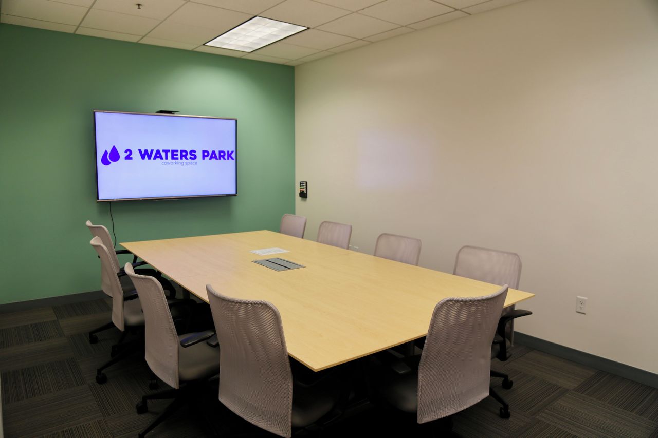 Modern conference room with large table and ergonomic chairs for meetings and events.