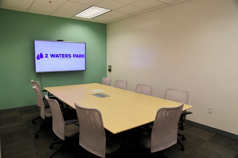 Modern conference room with large table and ergonomic chairs for meetings and events.