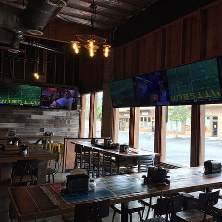 Modern event space at Parktown Pizza Company with large screens for networking events.