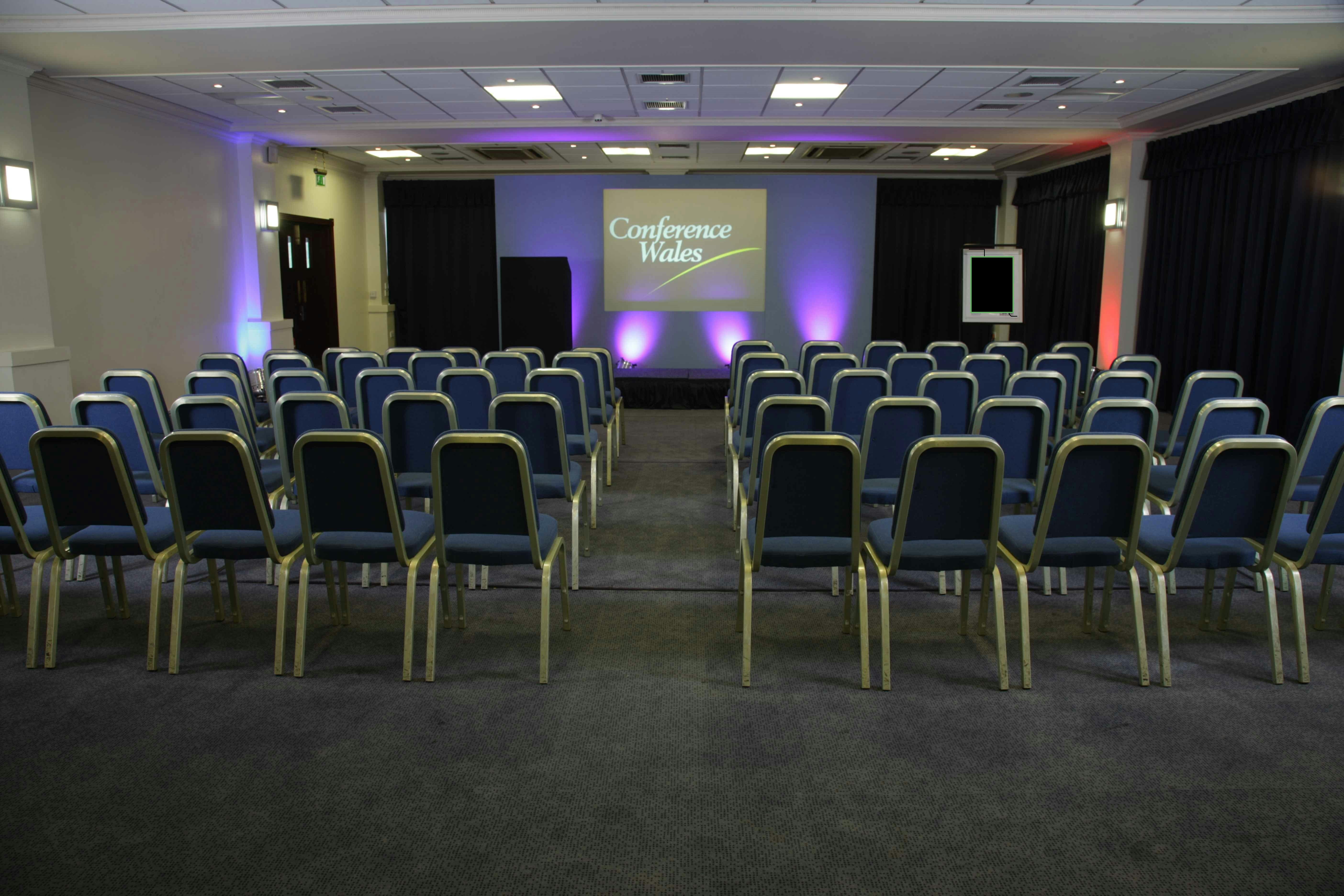 Carmarthen Suite conference room with blue chairs, ideal for presentations and workshops.