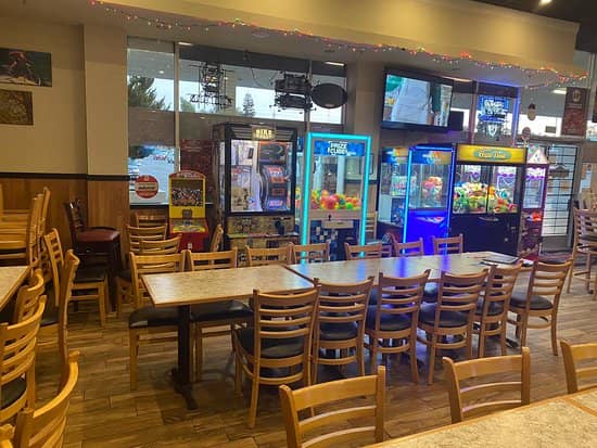 Casual dining area at Mountain Mike's Pizza with colorful arcade machines, ideal for family events.