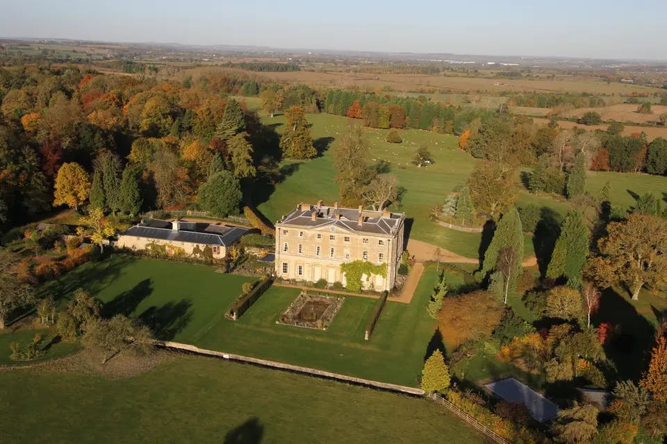 Filming at Courteenhall Estate with elegant architecture and vibrant autumn foliage.
