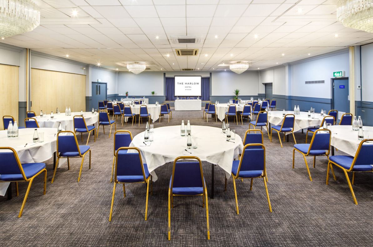 Buckinghamshire Suite at Harlow Hotel, corporate meeting space with round tables and projector. - Banner