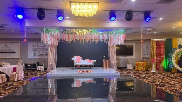 Elegant event space with floral stage, ideal for weddings and corporate events.