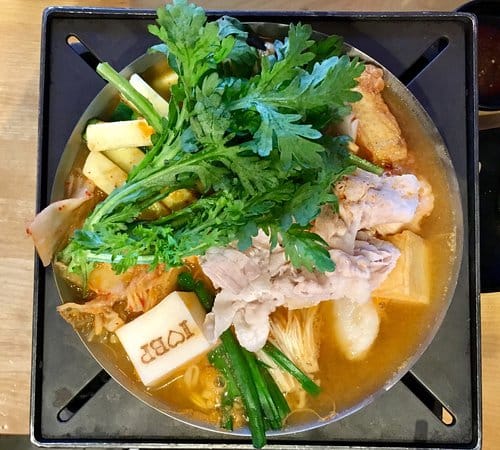 Vibrant hot pot bowl with fresh ingredients for engaging dining events at Boiling Point.