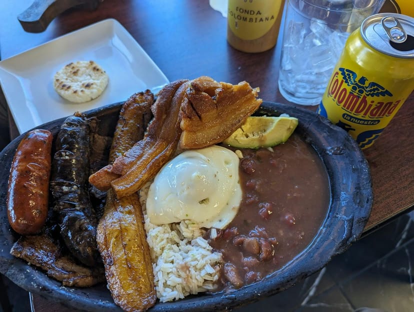 Vibrant Colombian dish with meats, rice, and plantains for events and catering.