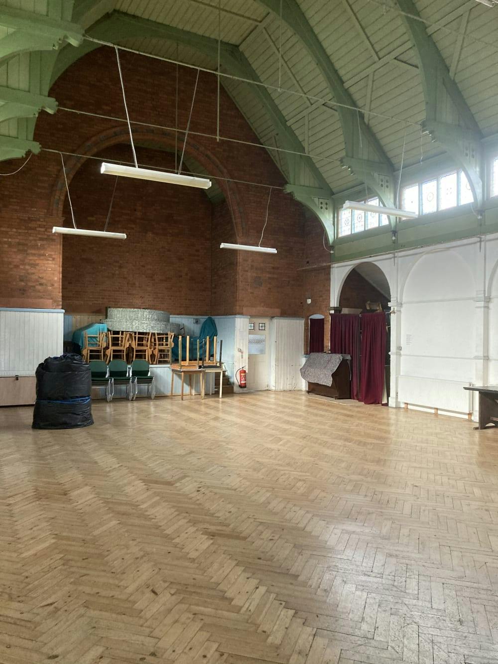 Main Hall in Haslemere Hall with wooden floor, ideal for events and gatherings.