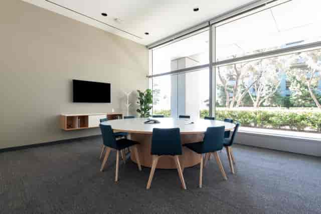 Modern meeting room with round table, natural light, ideal for collaboration and brainstorming.