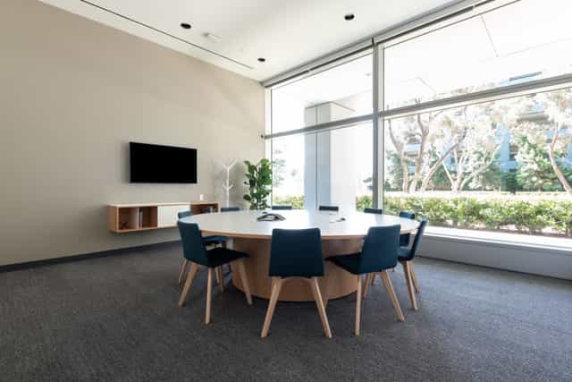 Modern meeting room with round table, natural light, ideal for collaboration and brainstorming.