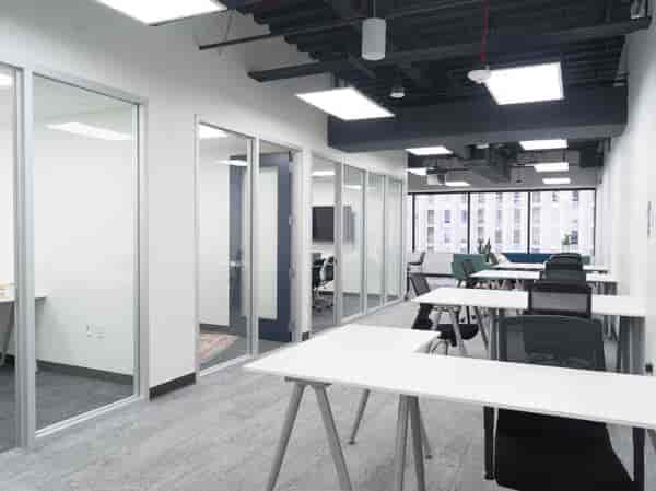 Modern meeting space with glass-walled rooms, ideal for workshops and team gatherings.