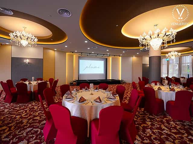 Elegant ballroom in Plume SG with round tables, ideal for conferences and banquets.